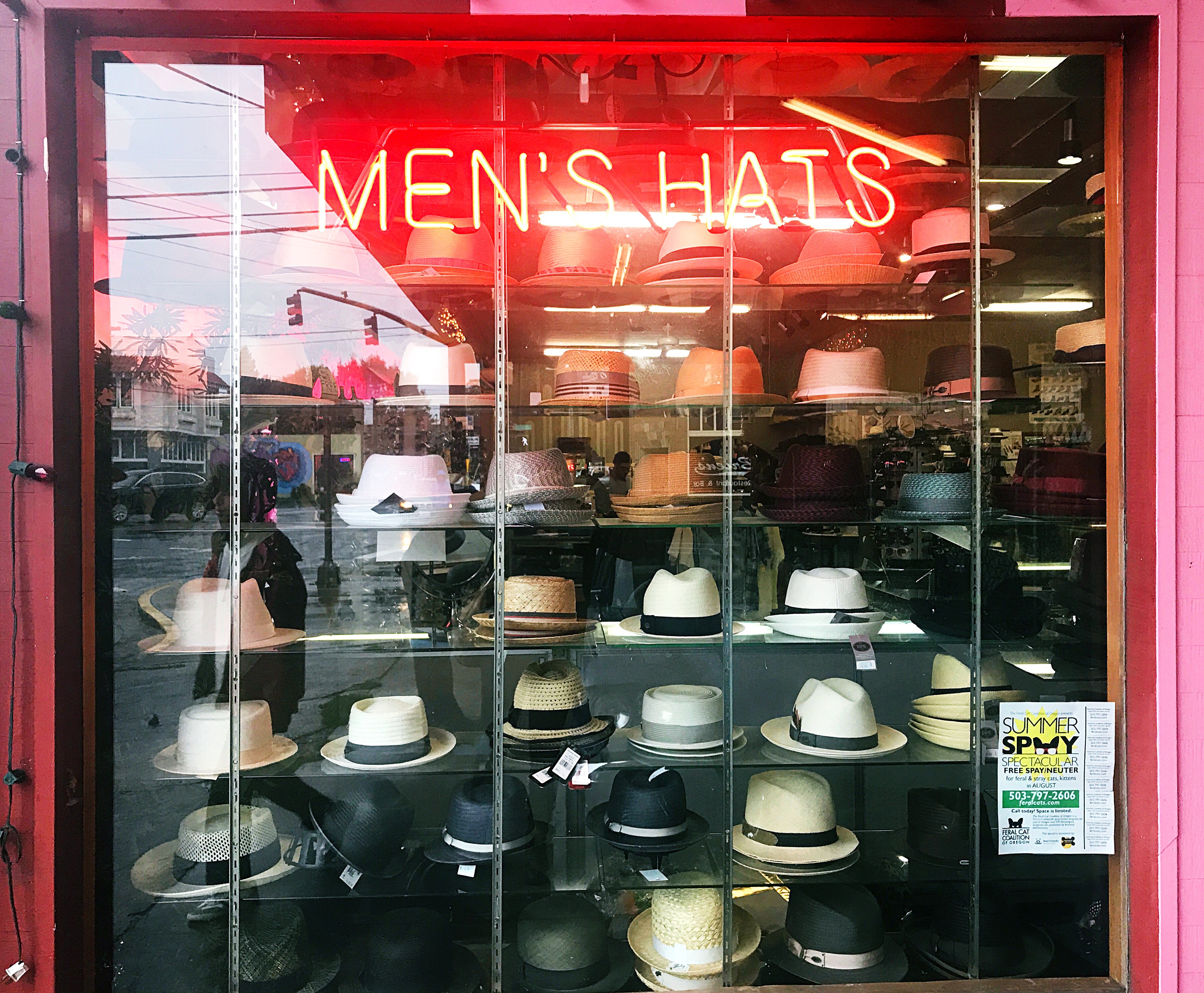Neon sign for hats in city storefront